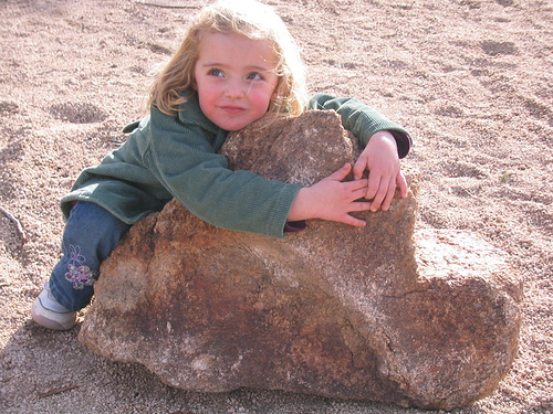 child hugging a rock
